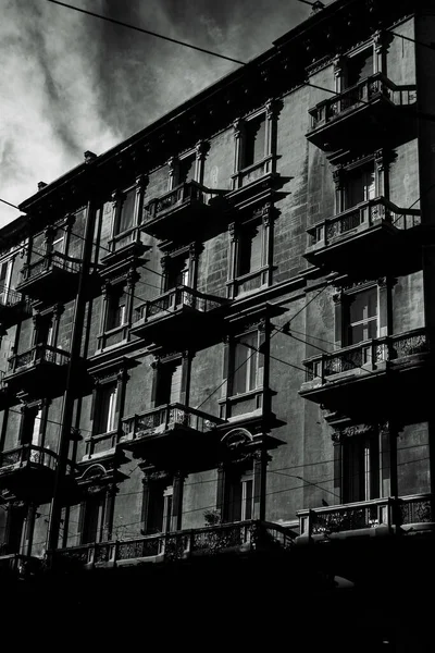バーリのバルコニー付きの古い建物の垂直ショット イタリアはグレースケールで撮影 — ストック写真