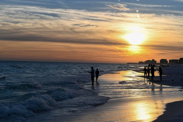 日没時にアメリカのフロリダ州デスティンのビーチを歩く人々のシルエット — ストック写真