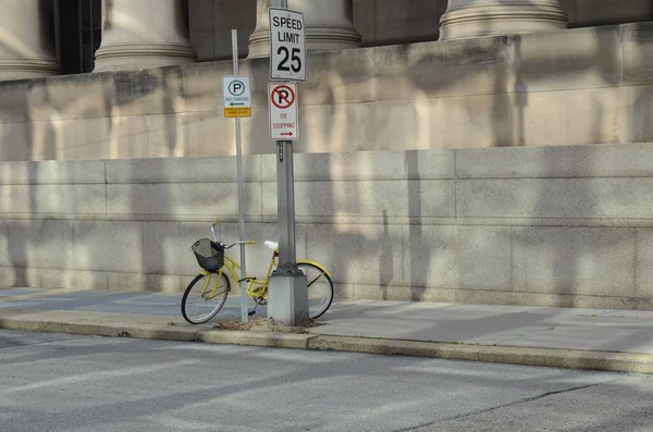 Tiro Bonito Uma Bicicleta Amarela Apoiada Pólo Com Placas Rua — Fotografia de Stock