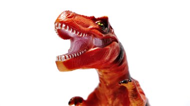 Beyaz arka planda izole edilmiş kırmızı bir dinozor oyuncağı.