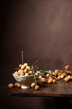 Tahta bir masada sepetteki taze Longan meyvelerinin seçici odak noktası.