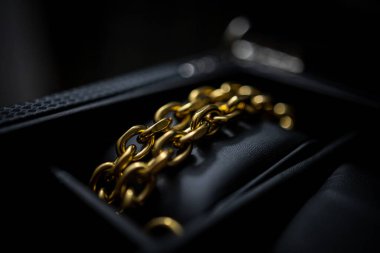 Altın zincirli küçük siyah bir çantanın yakın çekimi.