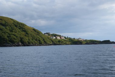 İskoçya 'da bulutlu bir gökyüzünün altında dağlar kadar güzel bir deniz dalgası manzarası.