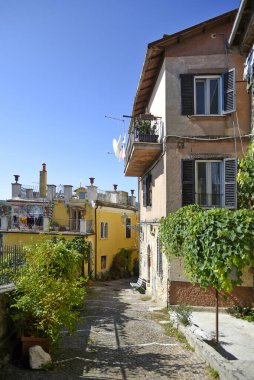 Fiuggi, Lazio, İtalya 'daki evlerin arasında dar bir kaldırım taşı ara sokağının dikey çekimi