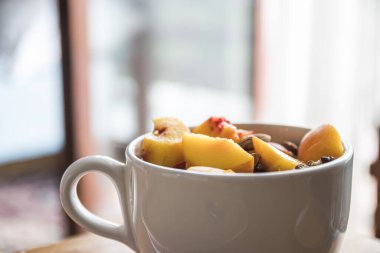 Şeftalili ve fındıklı bir fincan meyve salatası.