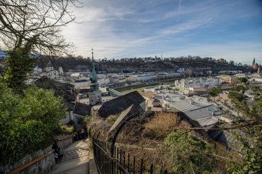 Gündüz vakti renkli binalar ve kiliselerle çevrili Salzburg şehrinin hava görüntüsü.