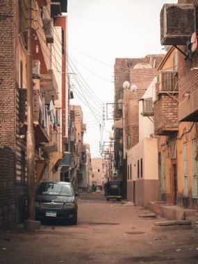 Park etmiş arabaların ve eski binaların olduğu güzel bir cadde manzarası.