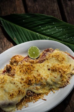 Lezzetli, etli ve peynirle kaplı bir yemek.