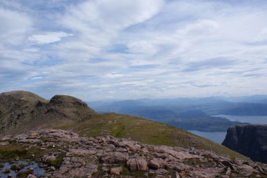 İskoçya 'da bulutlu bir günde gölün arka planında güzel bir uçurum görüntüsü.