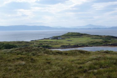 İskoçya 'da bir gölün yanındaki dağlarda bir ev