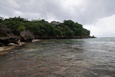 Deniz üzerindeki bulutlu gökyüzü Endonezya, Bali 'de bir sahilden rüzgarlı bir akşamda yakalandı.