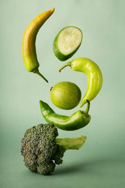 Svislý Záběr Létající Zeleniny Zeleném Pozadí — Stock fotografie