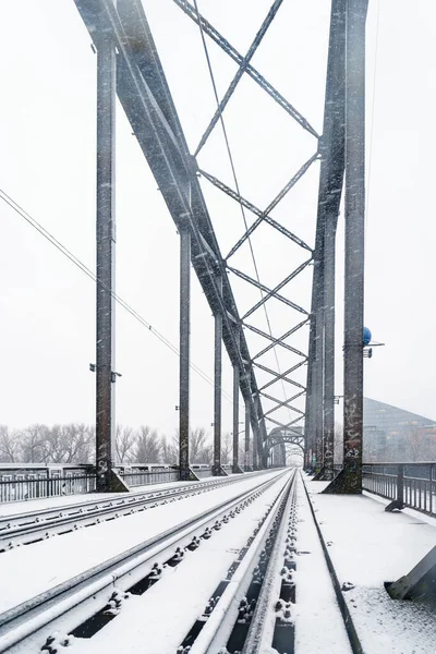 A vertical shot of a bridge with railways on it built from metal in Frankfurt, Germany