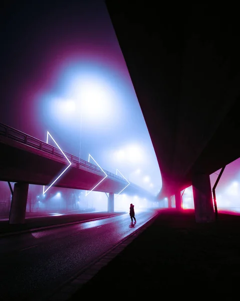在雾蒙蒙的夜市 一个人站在过道桥下的路中间 — 图库照片