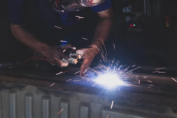 A welder welding automotive part in a car factory