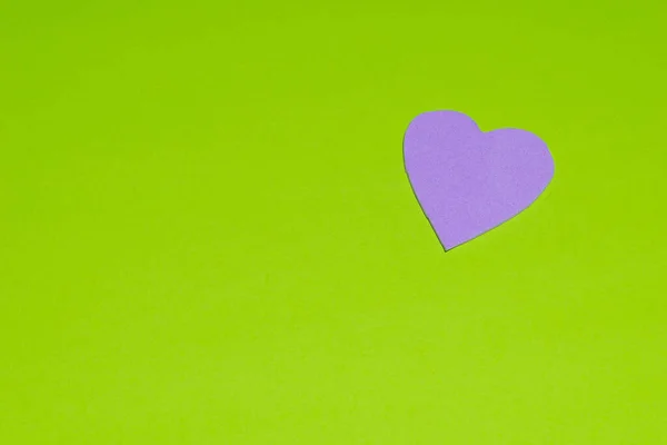 A top view of a purple heart cutout with a green background