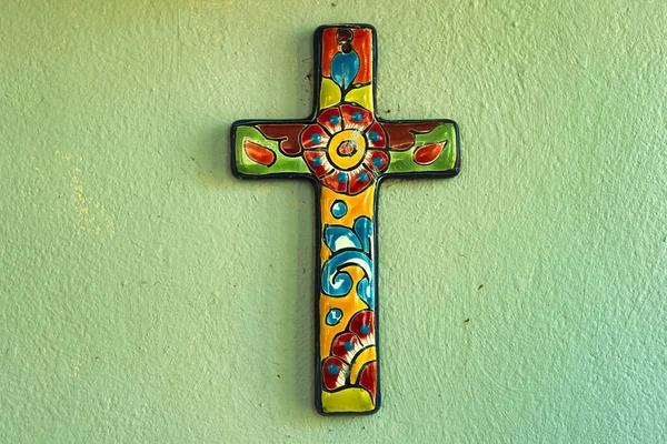 緑の背景に鮮やかな模様が描かれたカラフルな十字架 — ストック写真