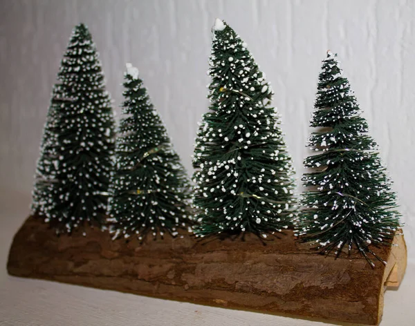 Detailní Záběr Čtyř Malých Vánočních Stromečků Sněhovou Texturou Dřevěném Povrchu — Stock fotografie