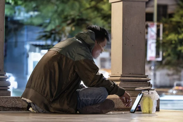 Молодой Человек Сидящий Улице Смотрящий Видео Телефону Ночью — стоковое фото