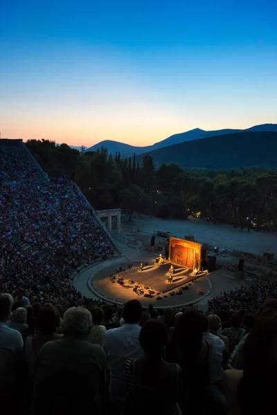 在暮色中坐在古希腊厄庇达罗斯古剧场前的人群的垂直镜头 — 图库照片