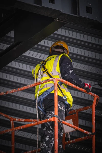 A back shot of a Construction worker on lift