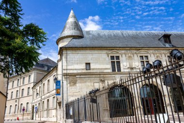 Bourges, Fransa 'da bulutlu bir gökyüzüne karşı çitleri olan tarihi bir bina.