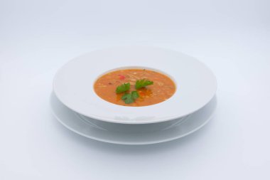 Beyaz arka planda bir kase çorbanın yakın plan çekimi.