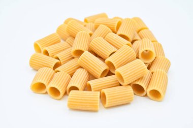 Beyaz arka planda çiğ rigatoni makarna yakın plan.