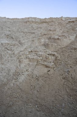 Gün batımında arkasında mavi gökyüzü olan bir kum havuzunun dikey görüntüsü.