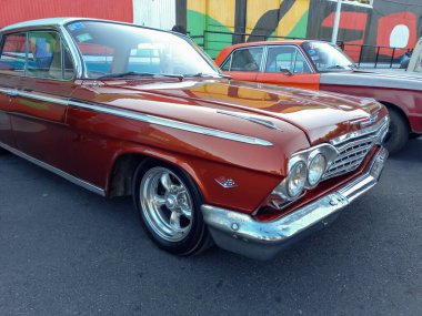 Eski popüler kahverengi Chevrolet Chevy Impala GM tarafından 1960 model dört kapılı sedan bir depo avlusuna park edilmiş. Ön manzara. Burun. Klasik araba şovu..