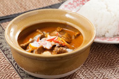 Süslü bir masada Tayland usulü tavuk ve beyaz pirinç tabağı.