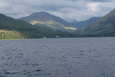İskoçya 'da bulutlu bir gökyüzünün altında dağlar kadar güzel bir deniz dalgası manzarası.
