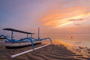 Sanur 'da, geleneksel balıkçı teknesi Bali ve Endonezya' nın üzerinde güneş doğuyor.