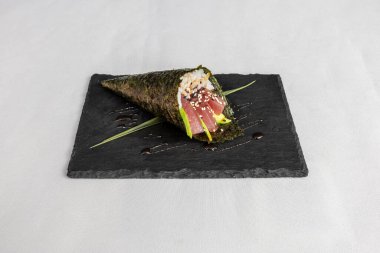 Beyaz arka planda siyah bir tabakta sushi 'nin üst görüntüsü