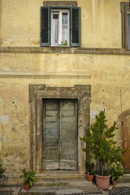 Fiuggi, Lazio, İtalya 'daki tarihi sarı bir binanın eski bir kapısının dikey görüntüsü.