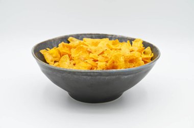 Beyaz arka planda izole edilmiş bir kasede yakın plan mısır gevreği fotoğrafı.