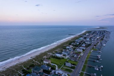 Gün batımında deniz manzaralı bir yarımadadaki evleri kuş bakışı izlemek.