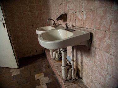 Svalbard 'daki terk edilmiş Sovyet kömür madenciliği yerleşim yerinin banyosunda iki eski lavabo.