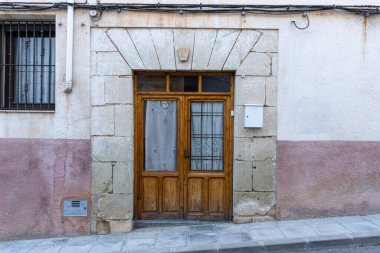 Eski bir beton binanın ahşap kapıları.