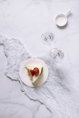 Çilekli kek ve gözlüklü bir tabağın üst görüntüsü.