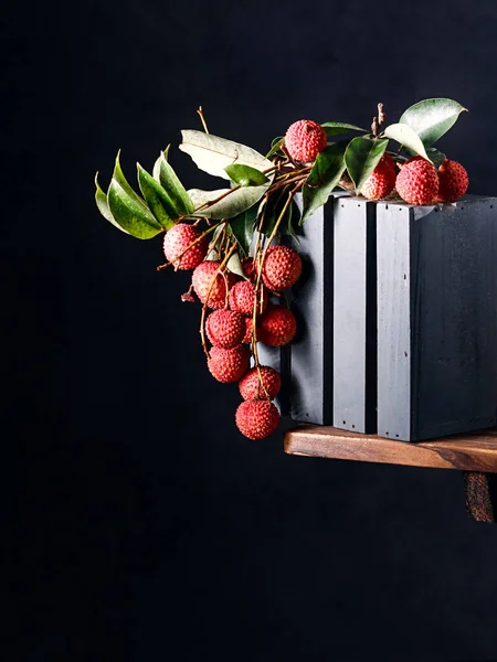 木のテーブルの上に緑の葉を持つ新鮮な熟したライチの果実の正面図 — ストック写真