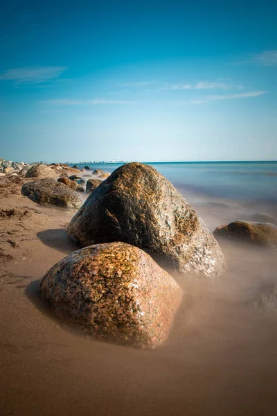 A selective of mossy stones on a sandy beach in the morning