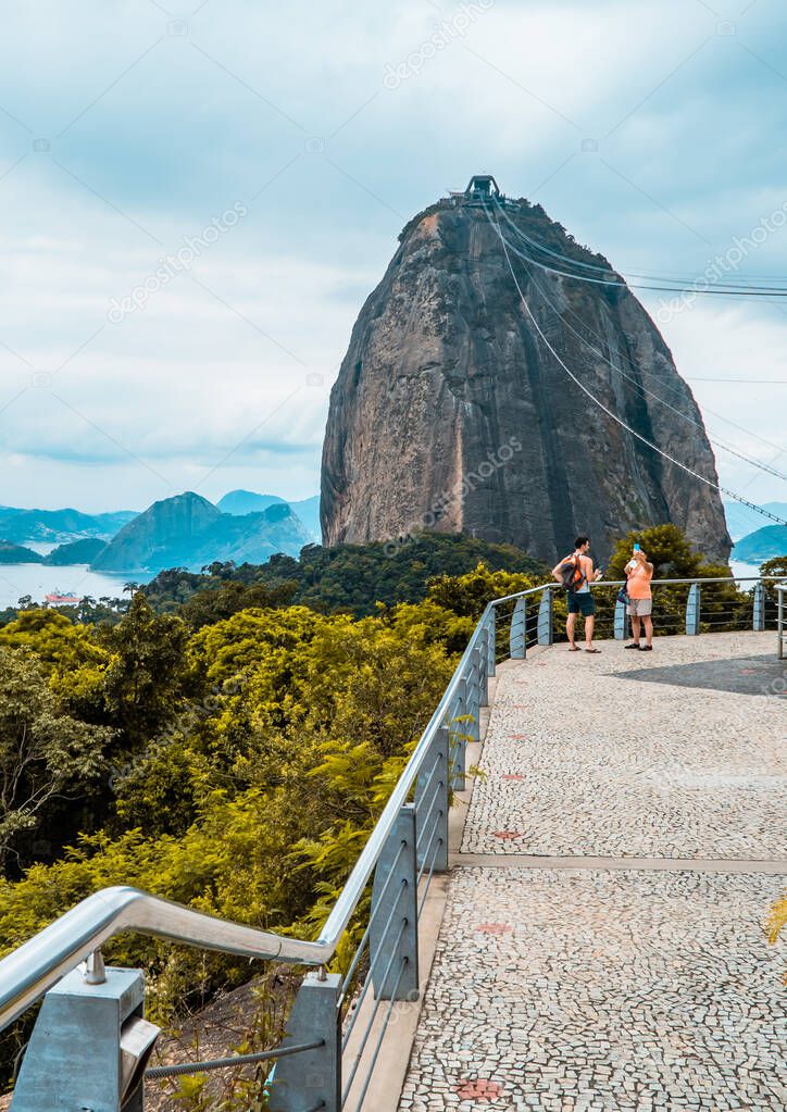 A vertical shot of tourists at Morro da Urca station with Sugarloaf Mountain in the background, Rio de Janeiro, Brazil