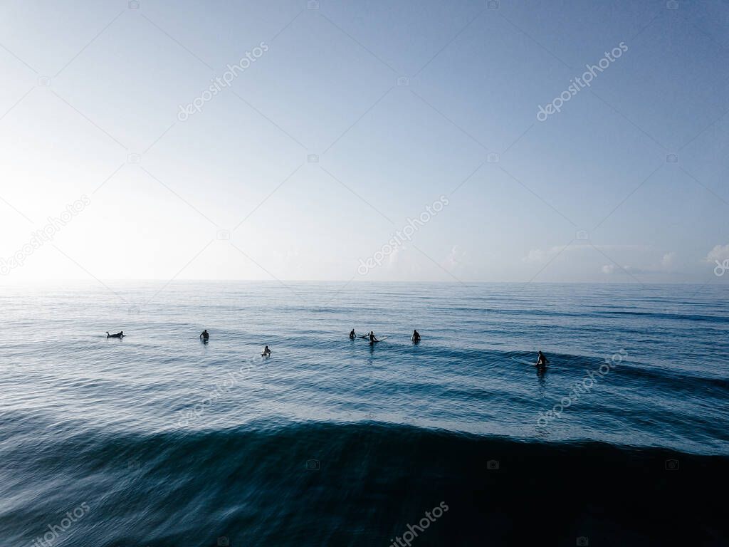 A beautiful shot of surfer resting on their boards in the blue sea