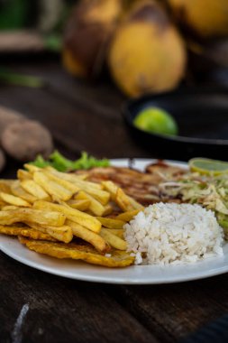 Bir tabak tavuk, patates kızartması, pirinç ve lahana salatası.