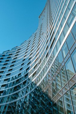 Vilnius 'taki modern bir binanın camlı ön cephesinin alçak açılı çekimi.