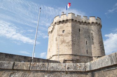 Mavi parlak gökyüzünün altındaki La Rochelle kulesinin alçak açılı görüntüsü.