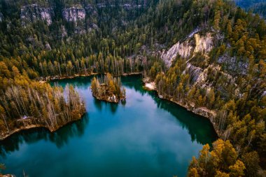 Çek Cumhuriyeti 'nin Adrspach kayalıklarında, ormandaki mavi bir gölün hava görüntüsü.