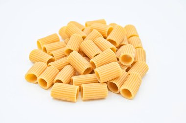 Beyaz arka planda beyaz bir kasede çiğ rigatoni makarnası.