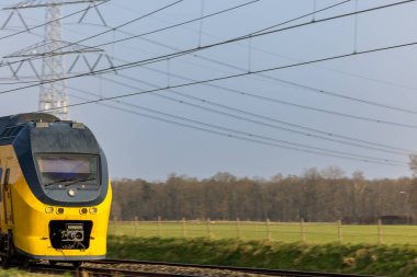 Hollanda, Limburg 'da tren raylarında sarı bir tren var.
